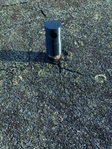 Risse und Verformungen im alten Dachbelag deuten auf akuten Sanierungsbedarf hin.